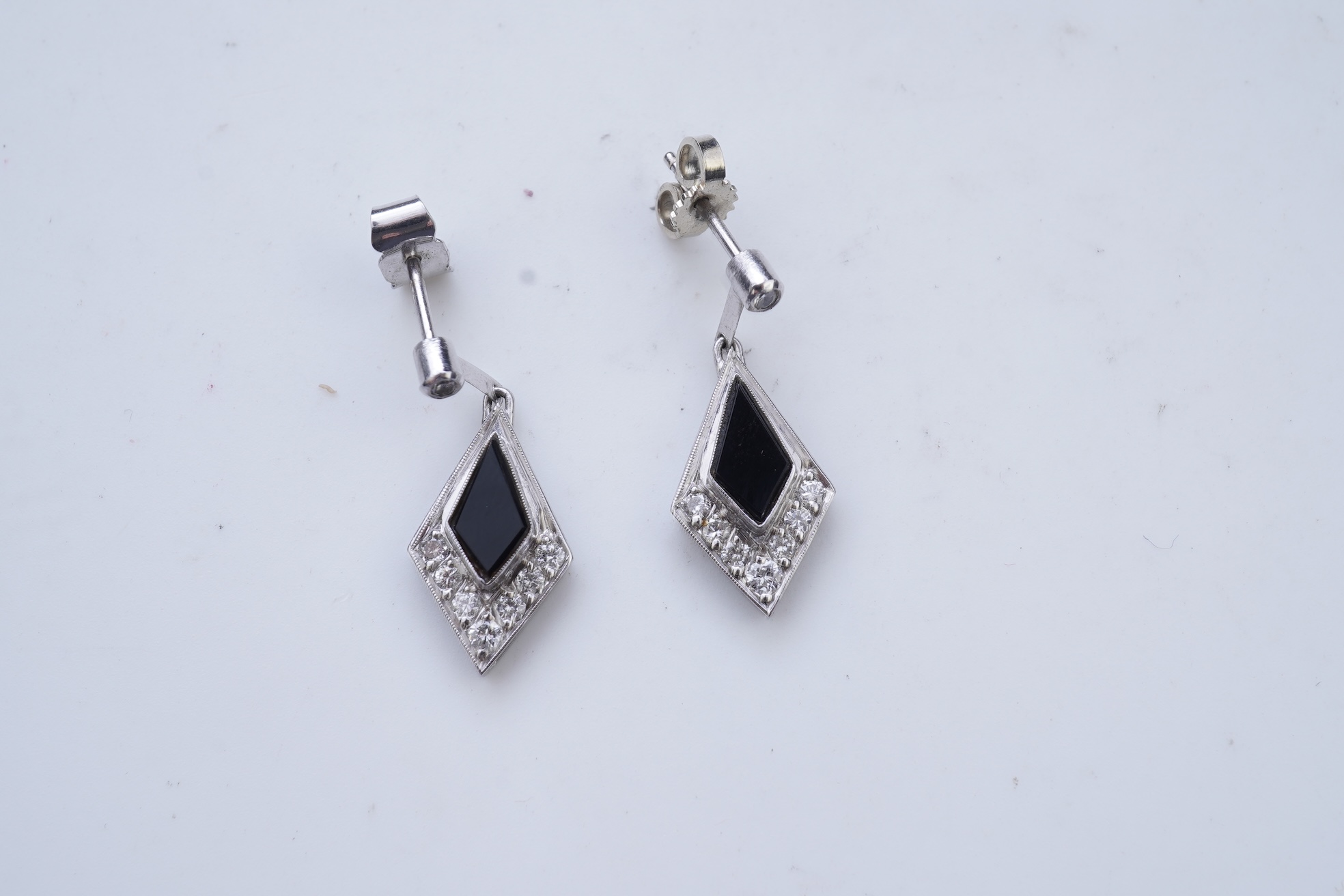 A pair of onyx and diamond earrings